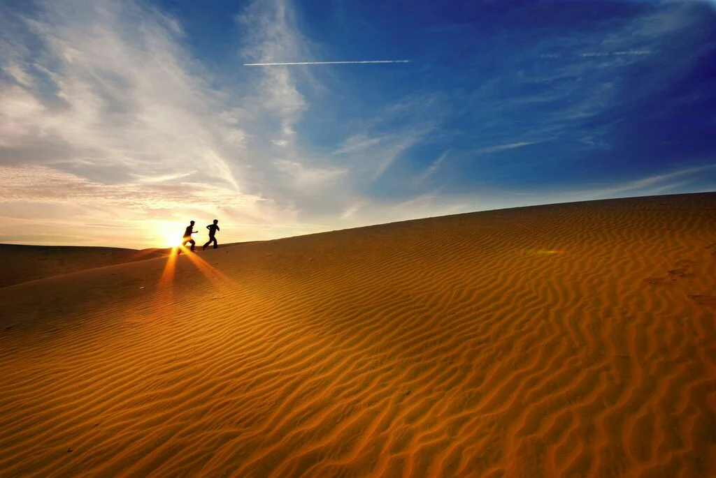 couple-running-on-sand-dune.